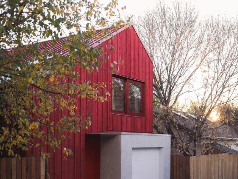 An angular Calgary laneway home by Bold Workshop Architecture featuring angular wood-framed construction with a rectangular concrete volume extending out from the base.