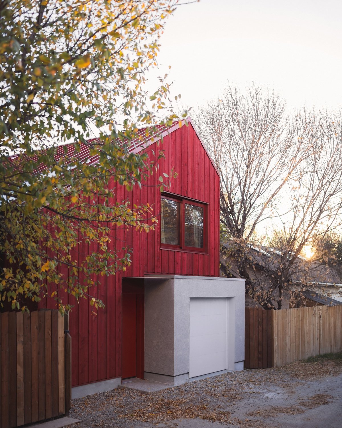 An angular Calgary laneway home by Bold Workshop Architecture featuring angular wood-framed construction with a rectangular concrete volume extending out from the base.