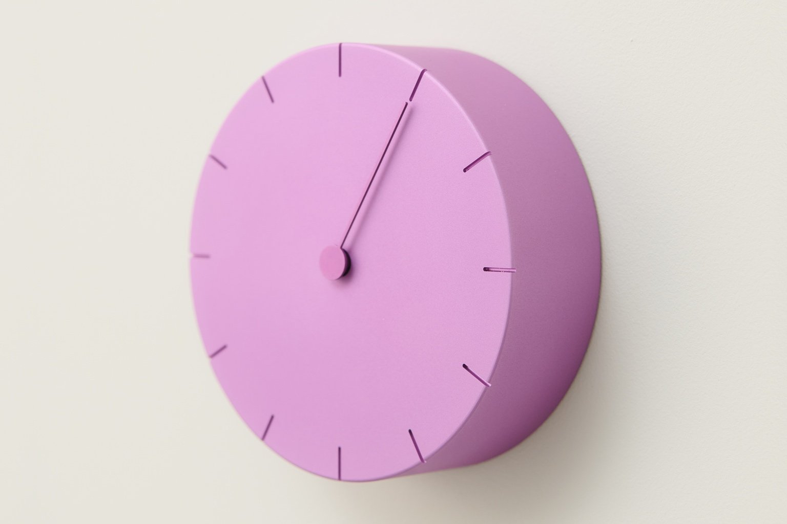 A lavender clock with only one hand, shown as part of a design typology exhibition during Milan Design Week 2025.