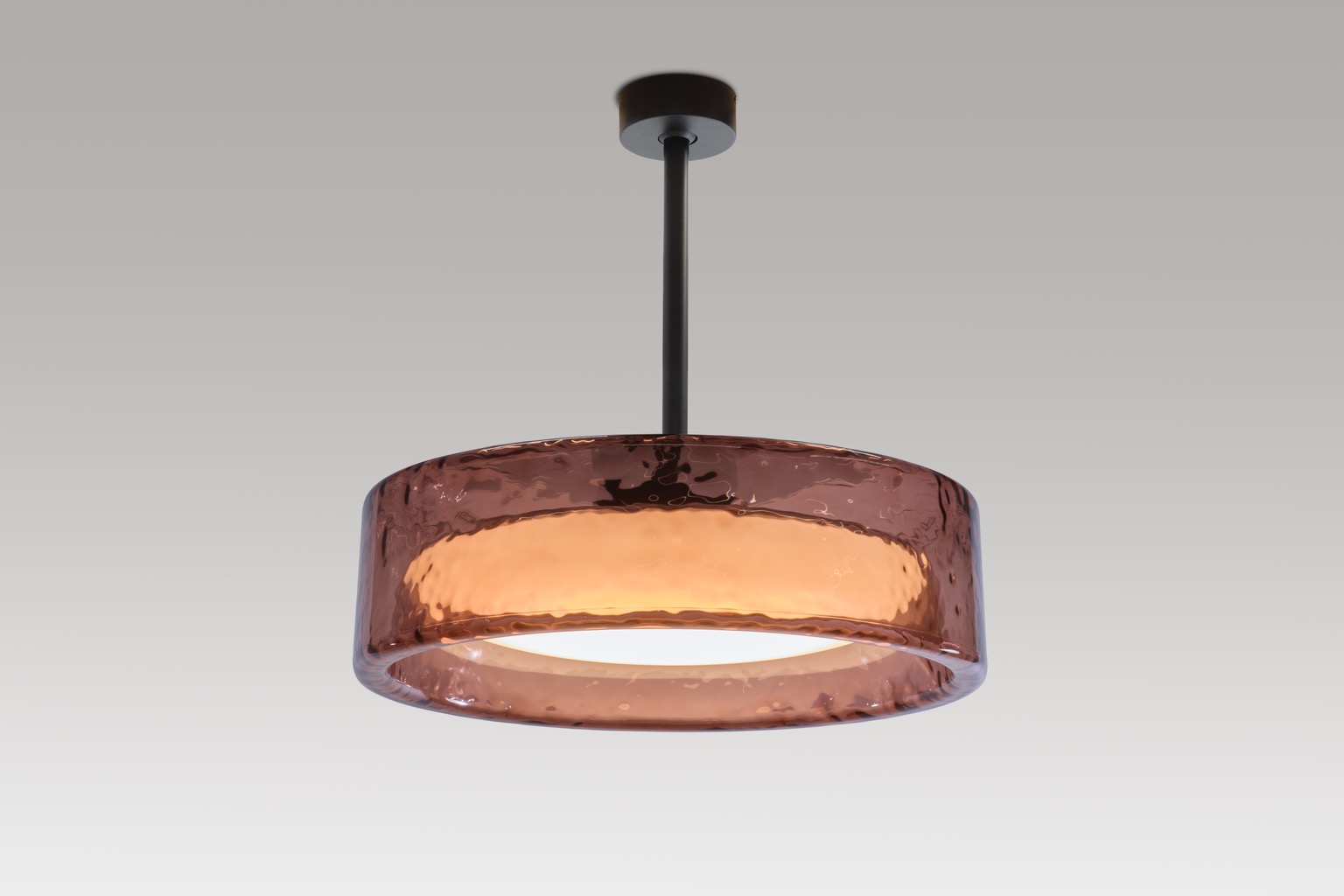 A rounded transparent amber pendant light. One of the modern brown furniture launches from Salone del Mobile 2025.