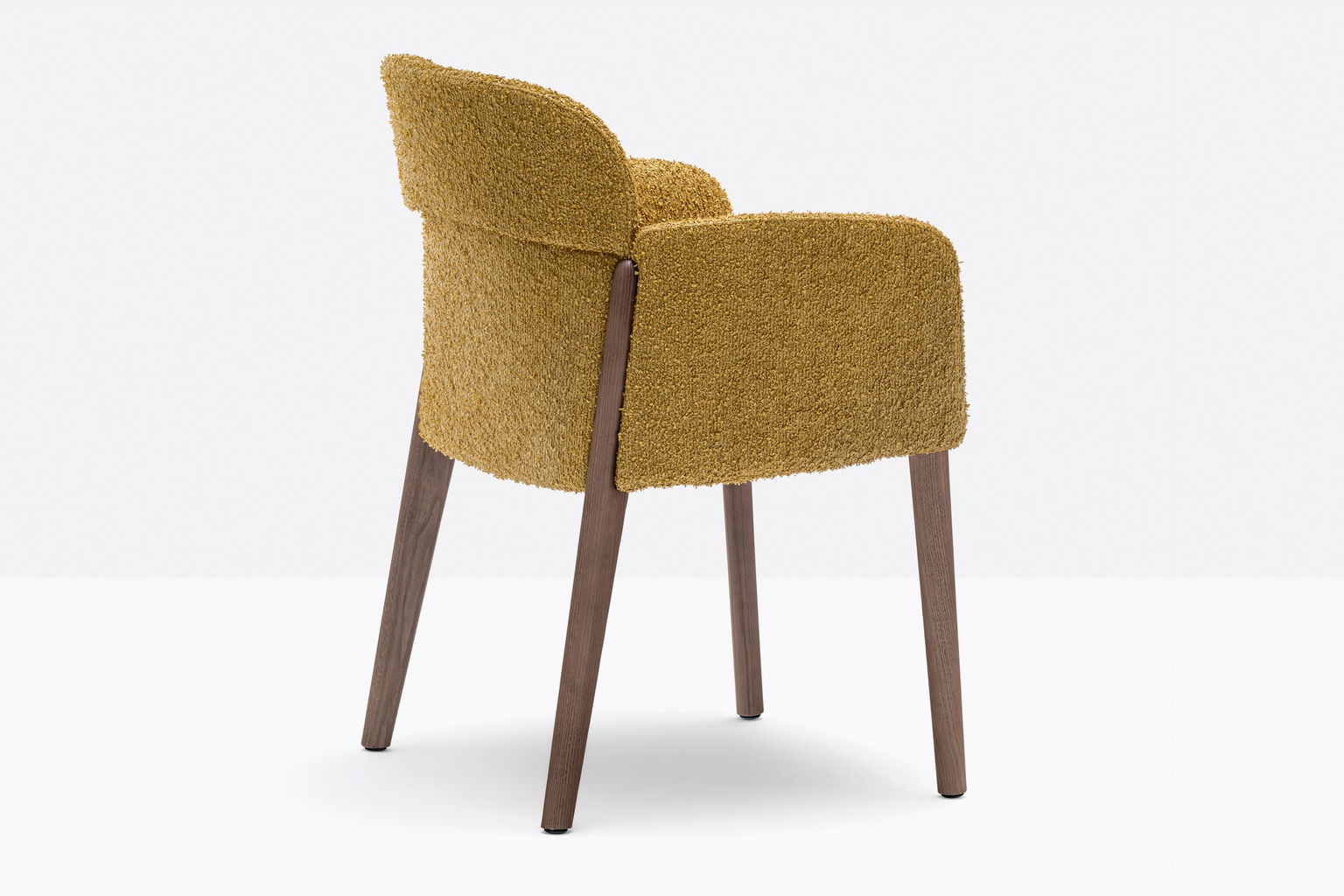 A chair with boucle yellow fabric and a handle built into the back.