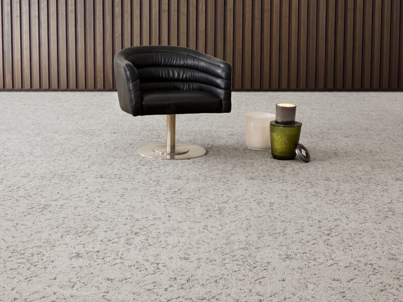 Lost Language gray carpet flooring by Bentley Mills with a black swivel chair and green and white jars on the right