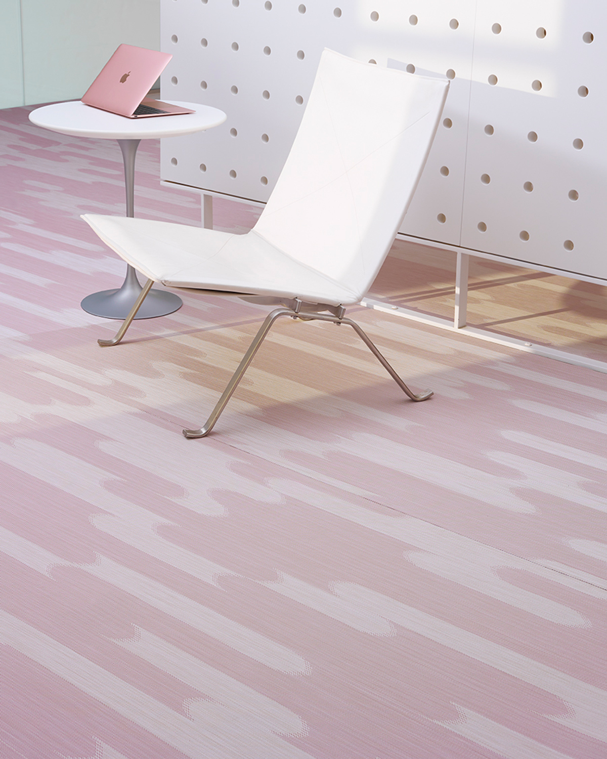 Pink and white Shuttle carpeting by Chilewich under a white chair and side table