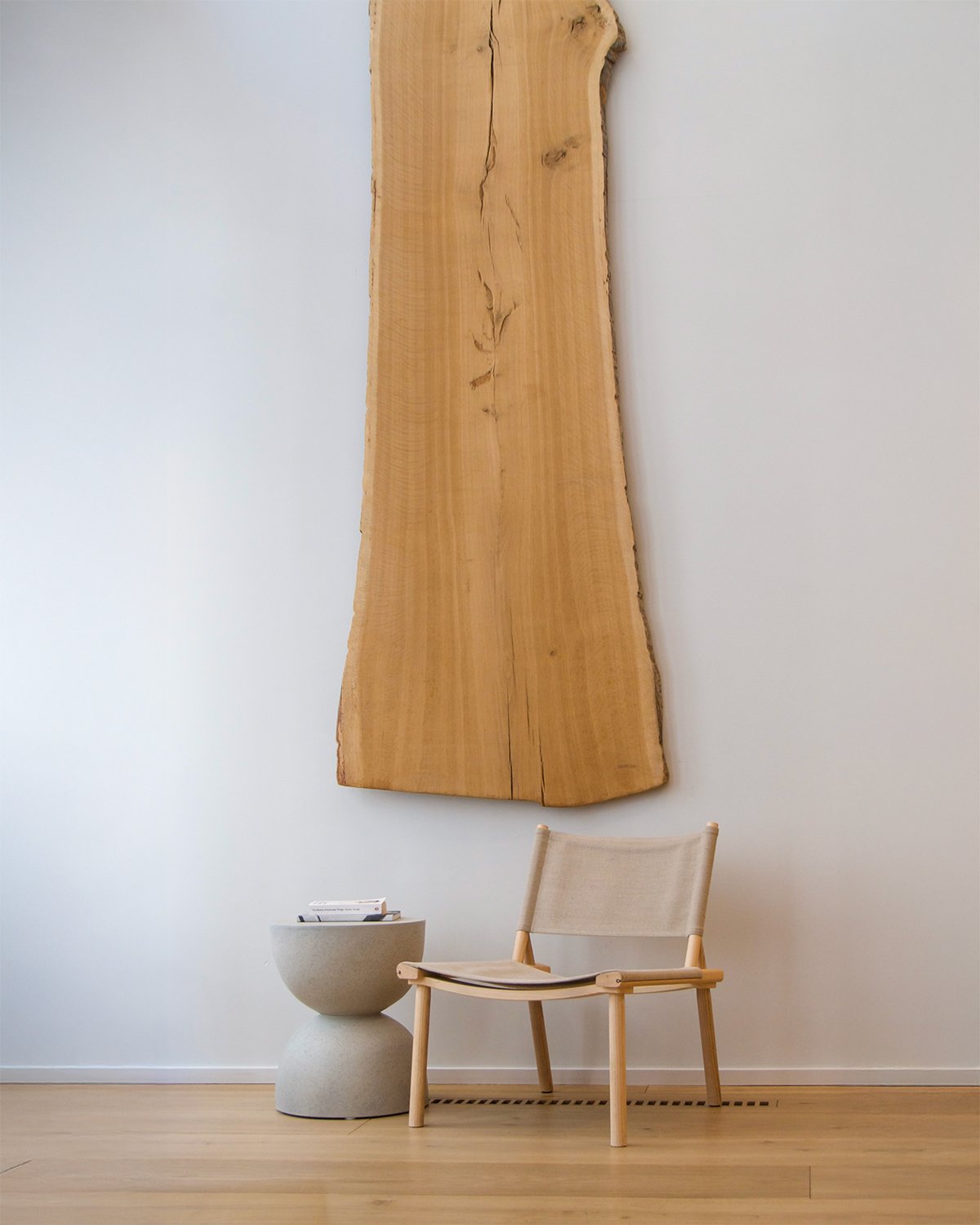 Seamless Wood Design by Madera with a wooden wall decoration, white chair and white side table