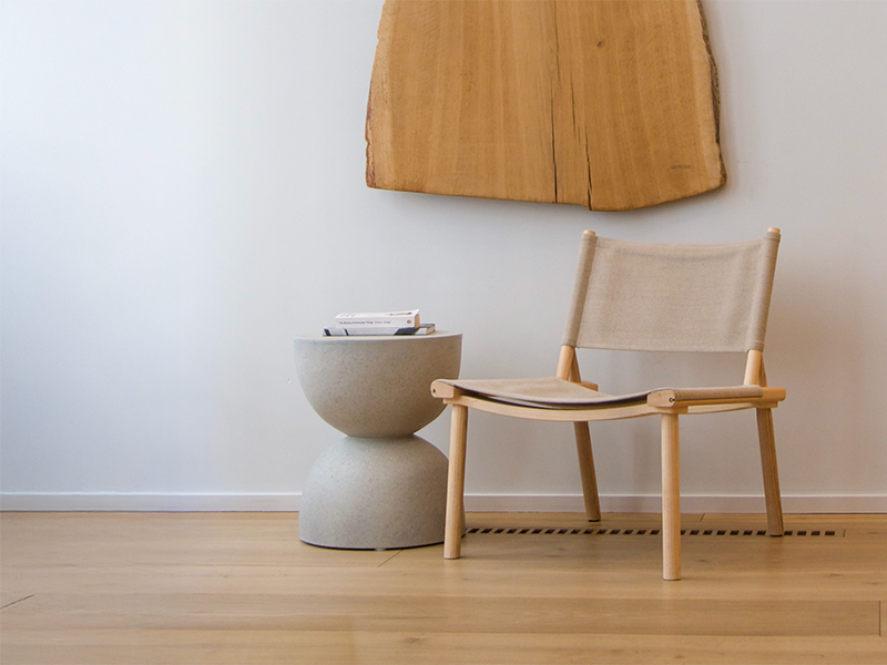 Seamless Wood Design by Madera with a wooden wall decoration, white chair and white side table