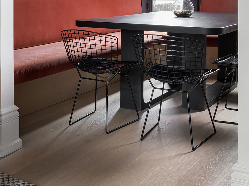Flyt Wide wood flooring by Studio Konior with black dining table and chairs