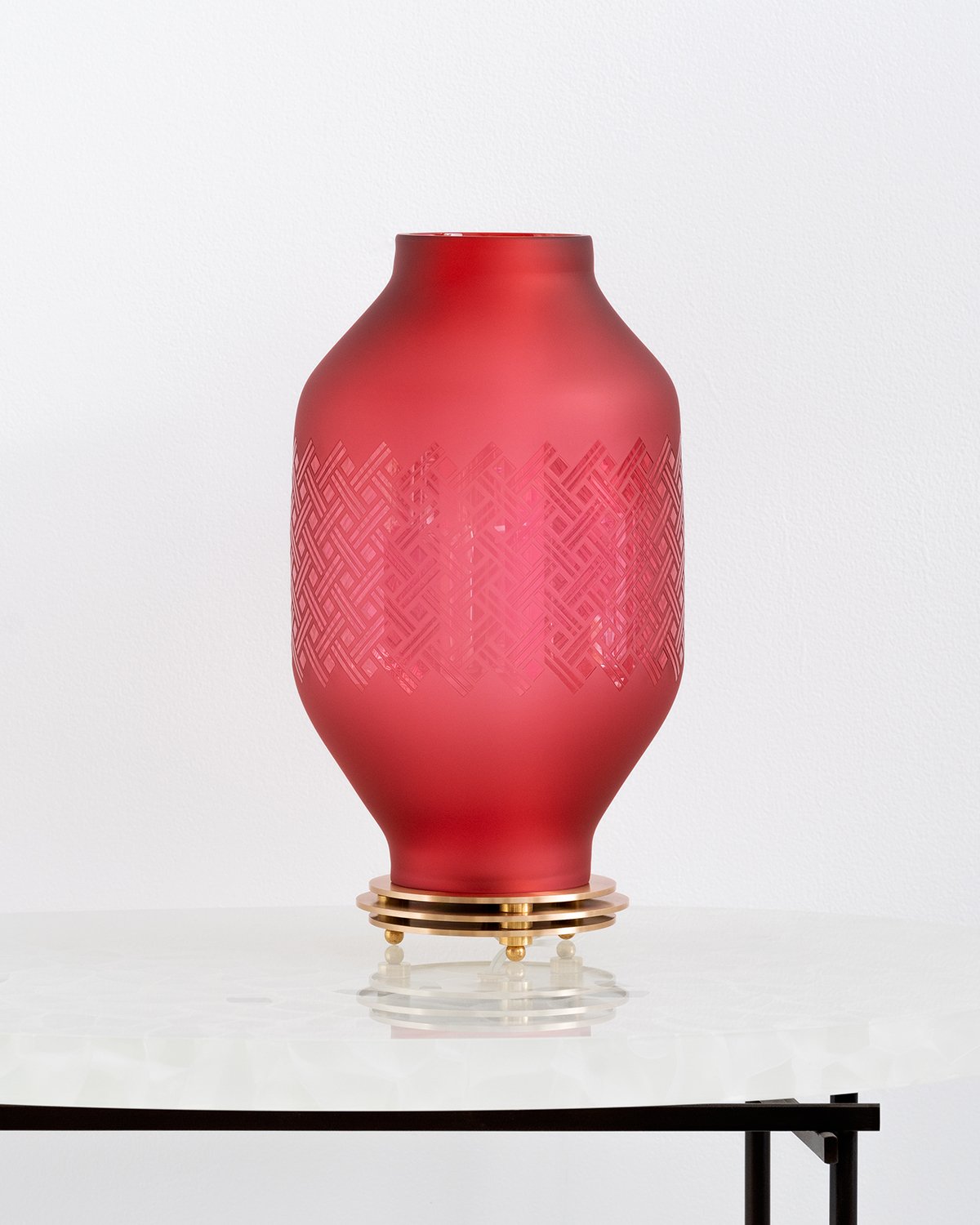 Red glass lantern by the goodman studio in a bright room