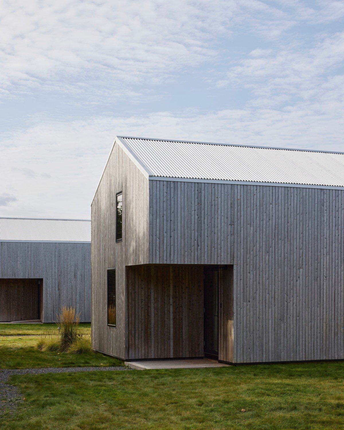 Two coastal modern rental cabins on Cape Breton Island designed by MacKay-Lyons Sweetapple Architects with notched corner patios.