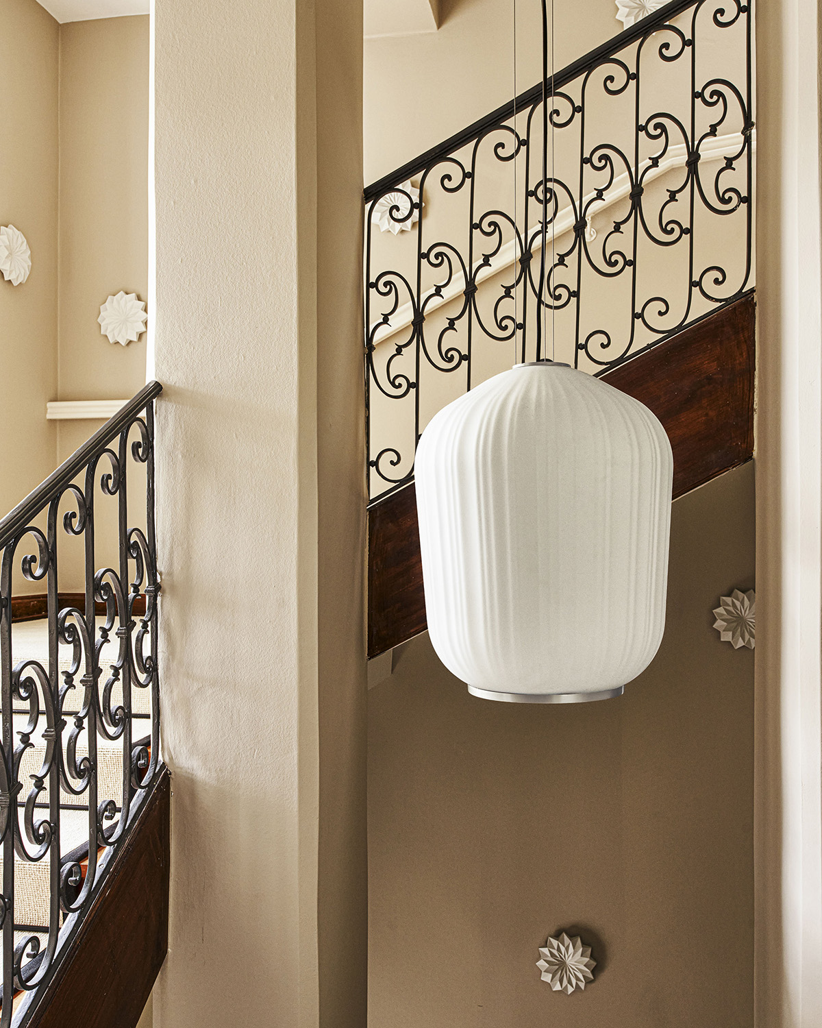 White pendant lamp hangs in a stairwell