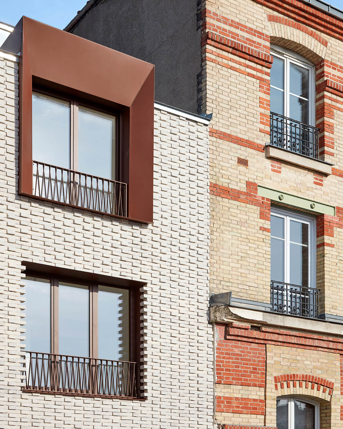 White brick building with brown aluminum window frames