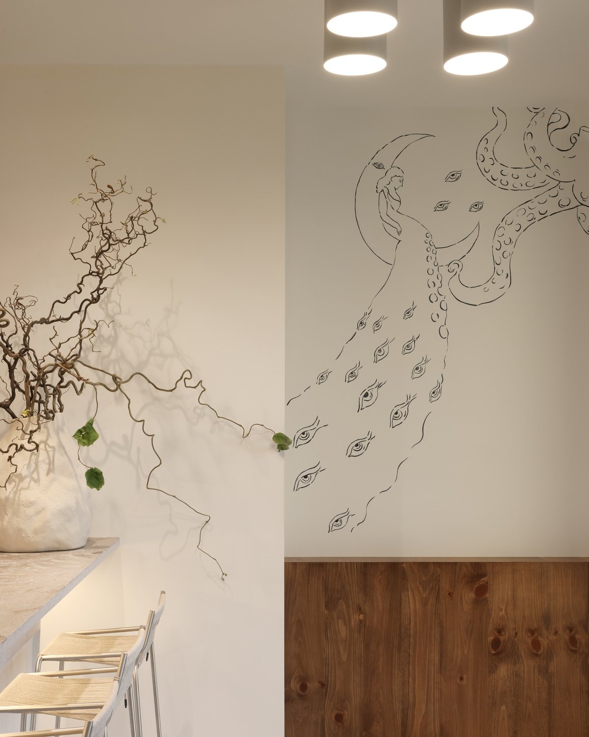 An illustration of an octopus and a person inside of a moon fills a white wall.