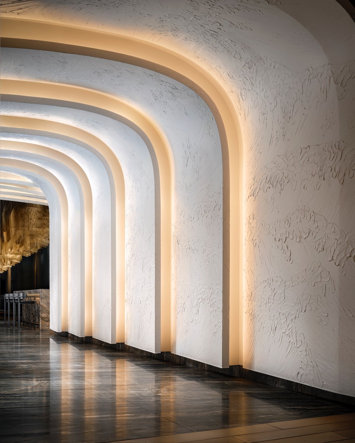 A hallway divided into glowing arches that resemble a wave.