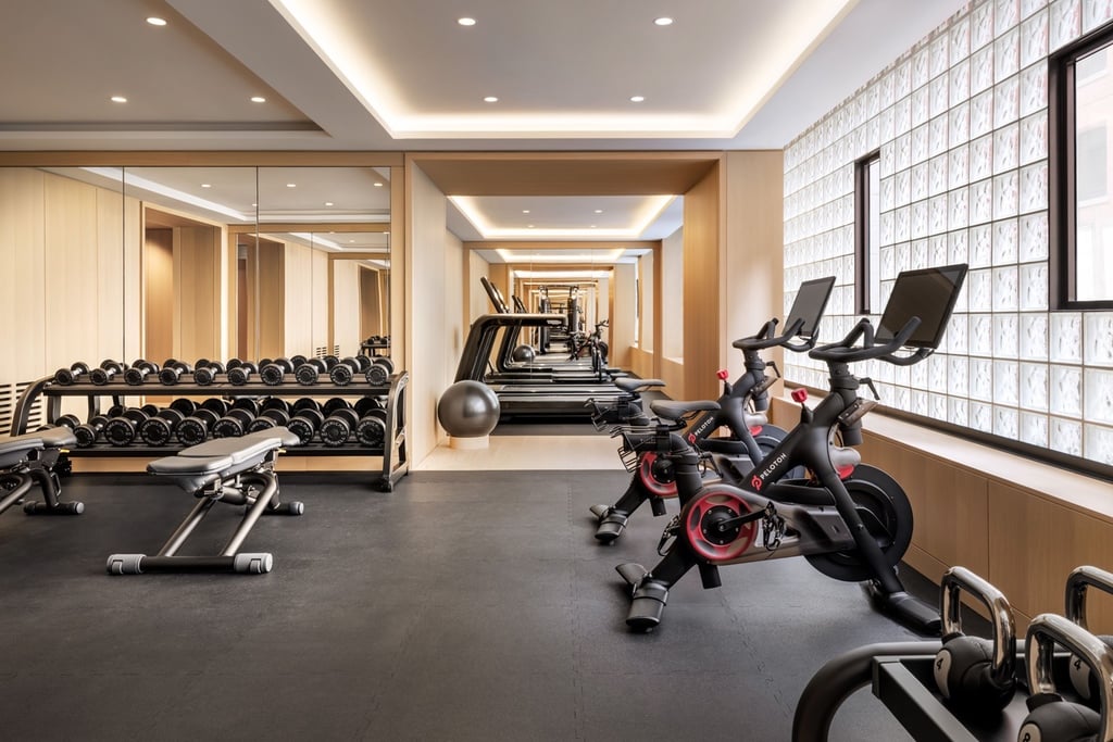 A fitness zone at Nobu Hotel Toronto with Peloton bikes facing a glass brick wall.