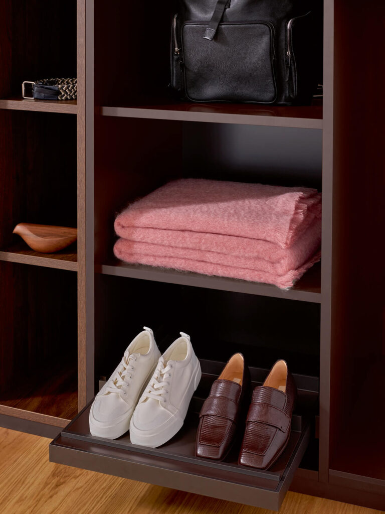 Wooden closet with open shelving, displaying blanket and shoes