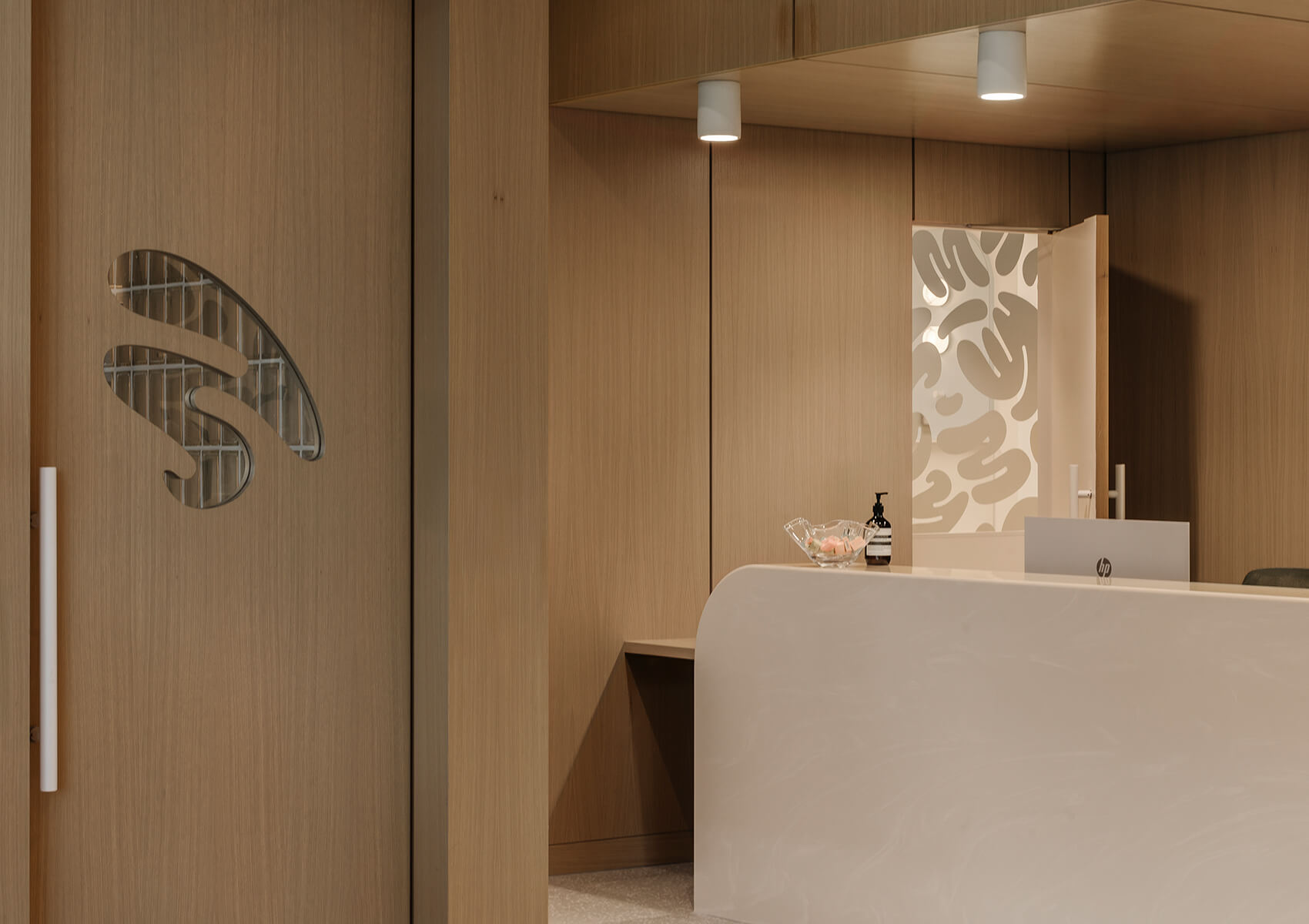 Dental clinic reception area with wood walls and white Corian counter