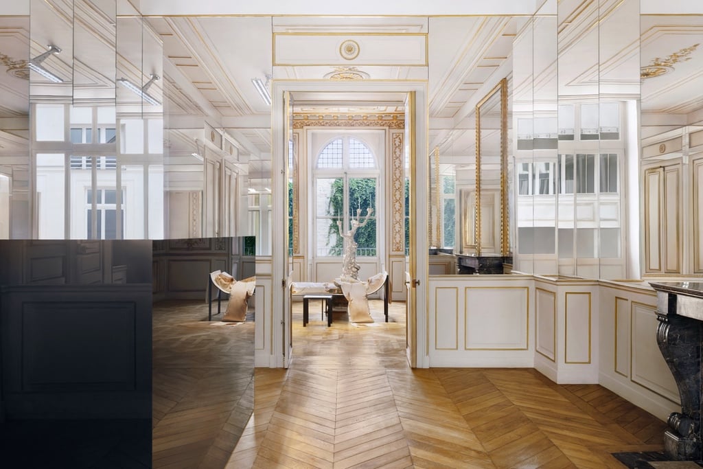A mirror-clad hallway in an ornate house with lots of gold trim.
