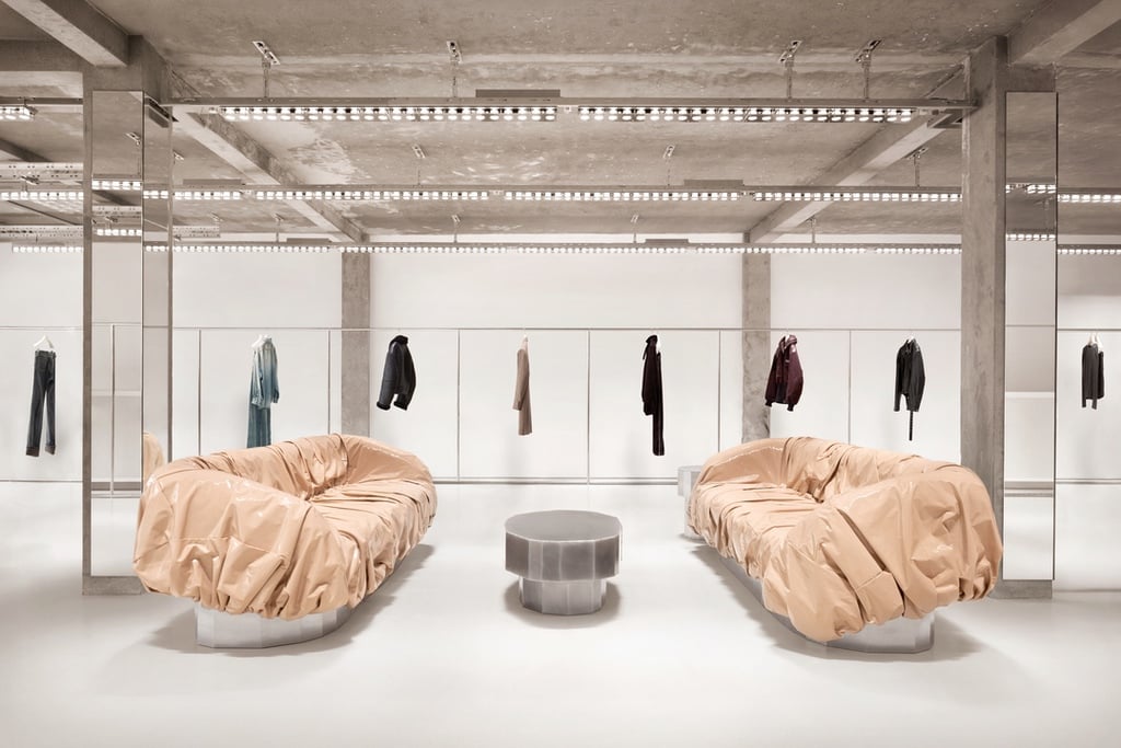 Two sofas covered in crumpled, cream-coloured vinyl at the Acne Studios Paris showroom designed by Halleroed in a former science lab.