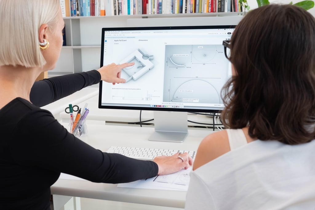 The hand of Dutch designer Sabine Marcelis points to a computer monitor with a mockup of an installation she was working on for an Apple iPhone launch event.