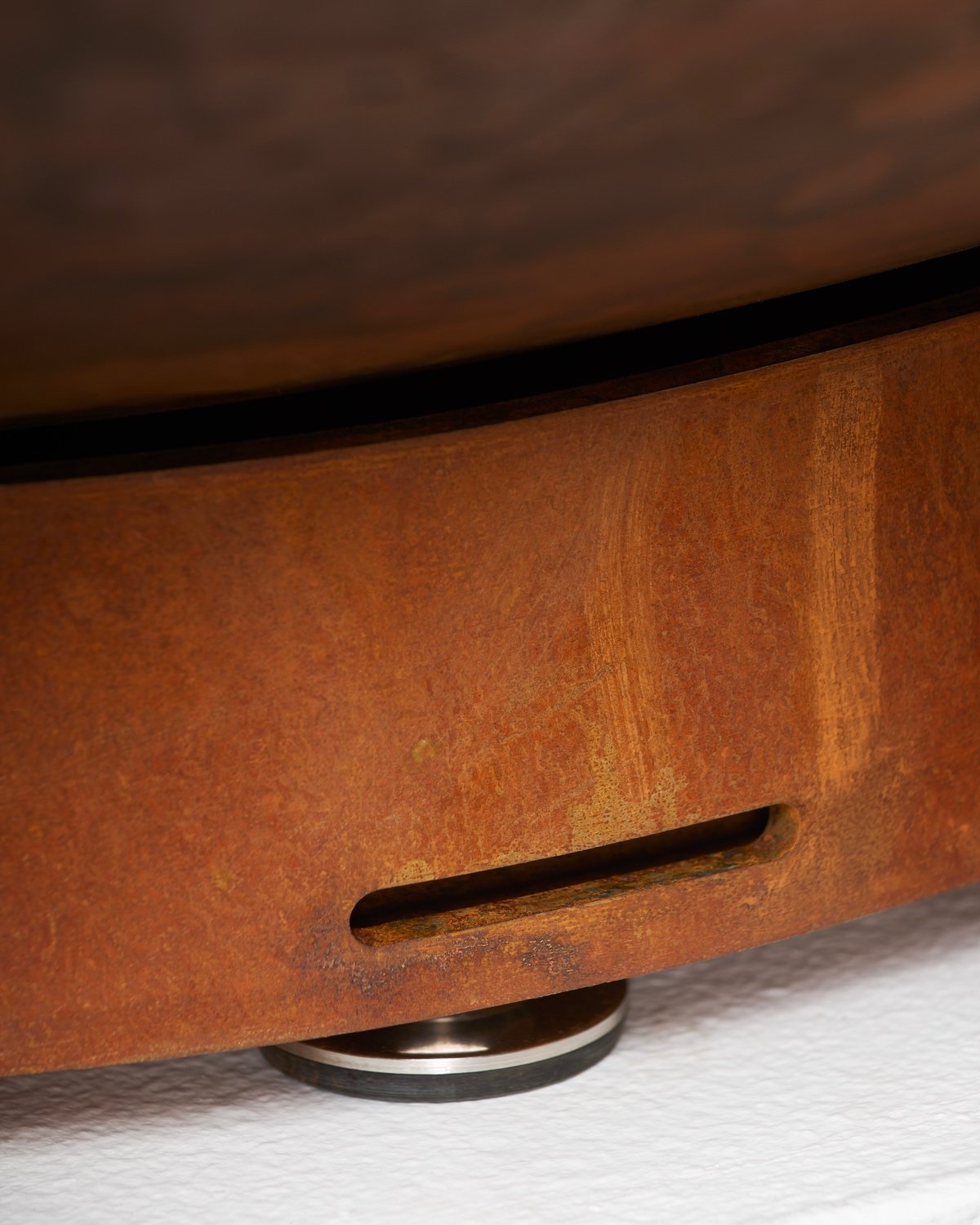 A drainage slot in the Corten steel dish below an Été planter.