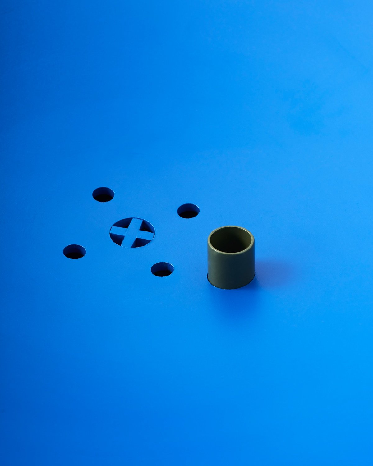 A detail of the drainage holes at the base of a blue Été planter.