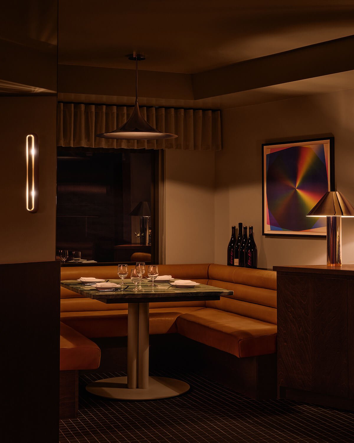Restaurant booth with tan leather banquette and green marble table