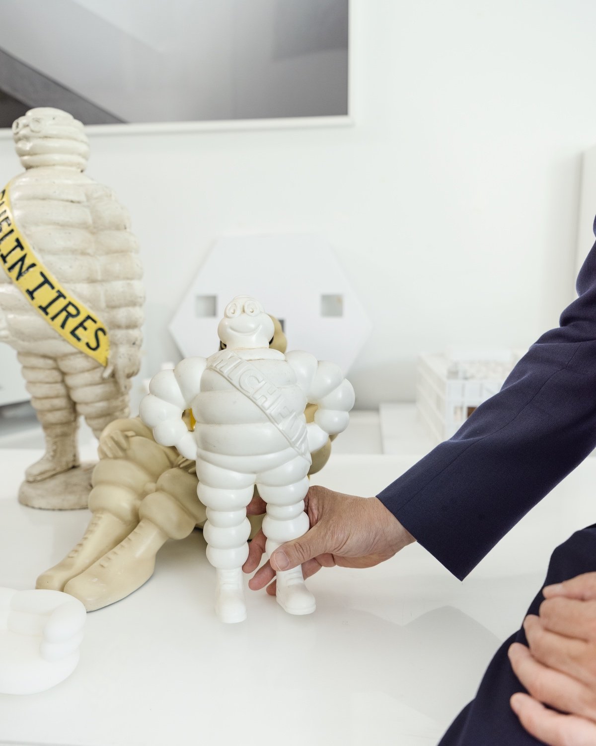A hand holding a model of the Michelin Man character.