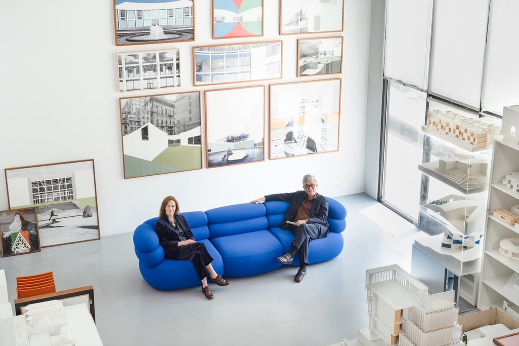 Architects Sharon Johnston and Mark Lee on a blue Knoll Biboni sofa in their white studio space.