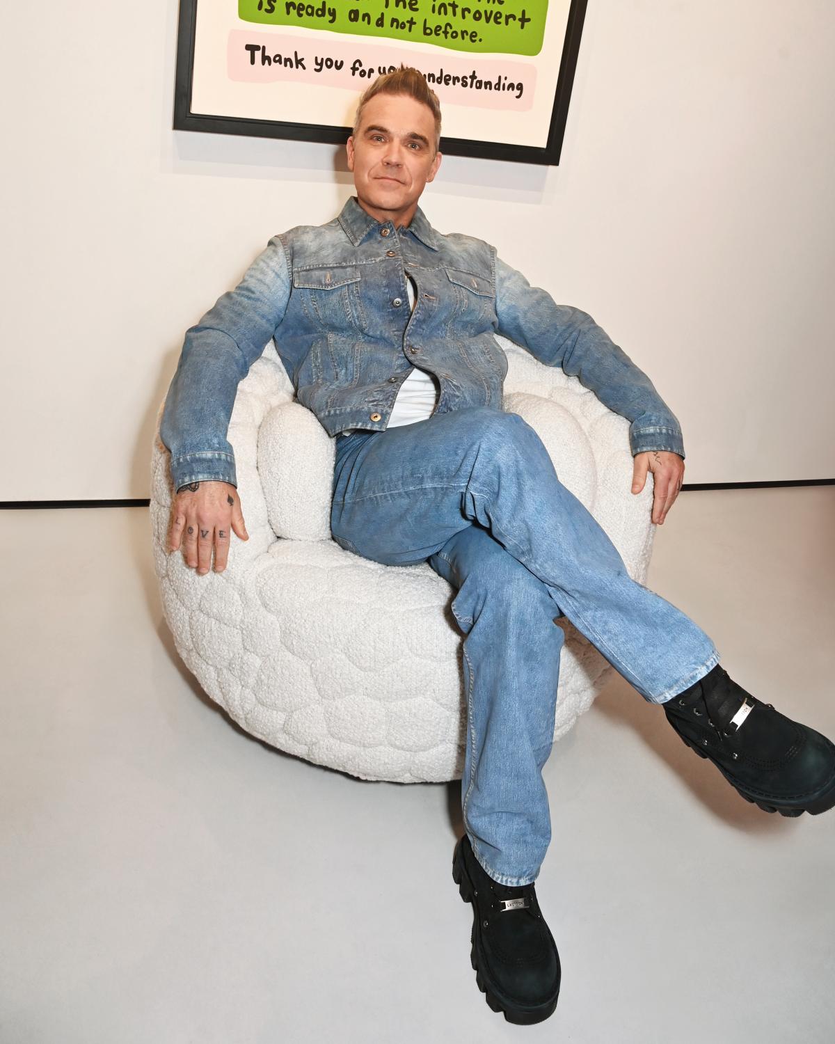 Robbie Williams sits in the Introvert chair he designed for Moooi
