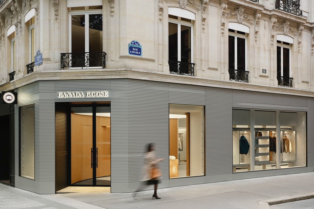 The exterior of the Canada Goose Paris flagship designed by Snohetta, featuring a ridged aluminum facade installed at the base of a historic residential building.
