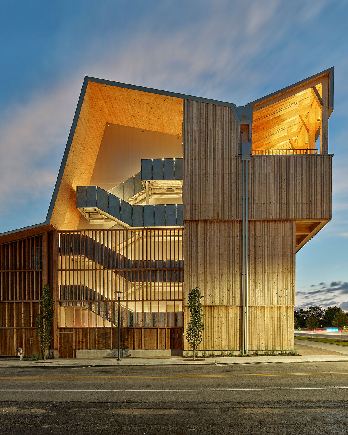 Zig-zagging facade of the Anthony Timberlands Center at night with glowing staircase.