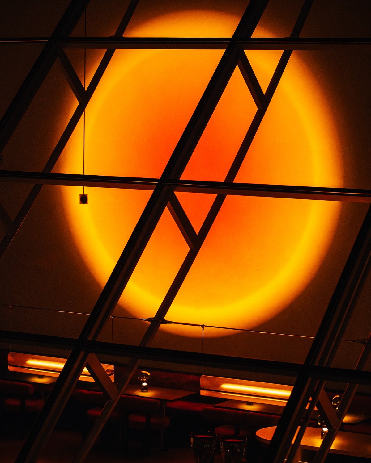 A light projects a sunset-coloured circle onto a wall at Ellipsis Vancouver.