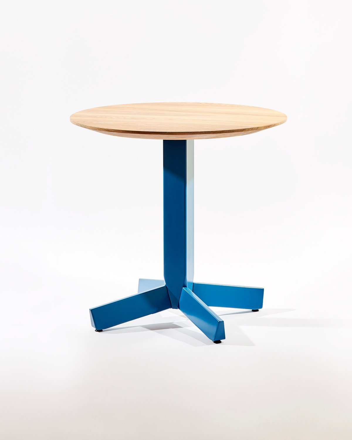 A side table with a wooden top resting on a blue metal base designed by Nicole Marion for the modern Canadian furniture brand Ourse.