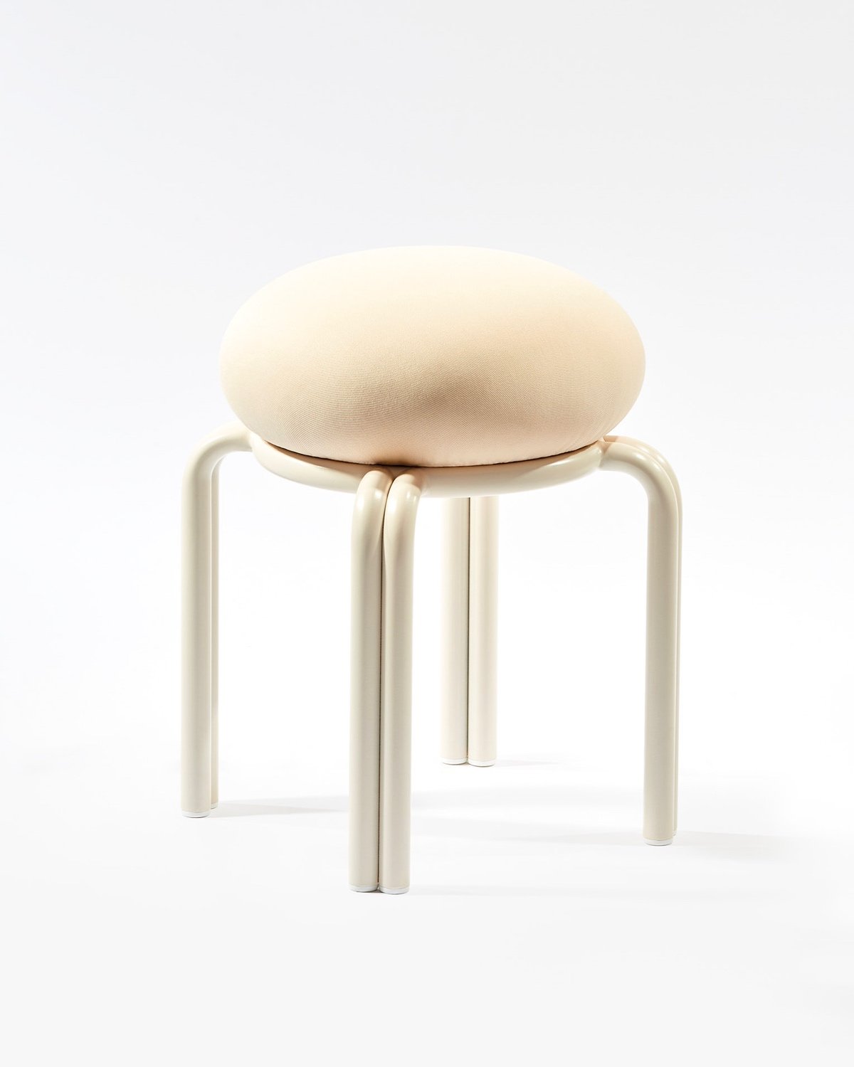An upholstered cushion on a base featuring four legs created from pairs of rounded steel rods.