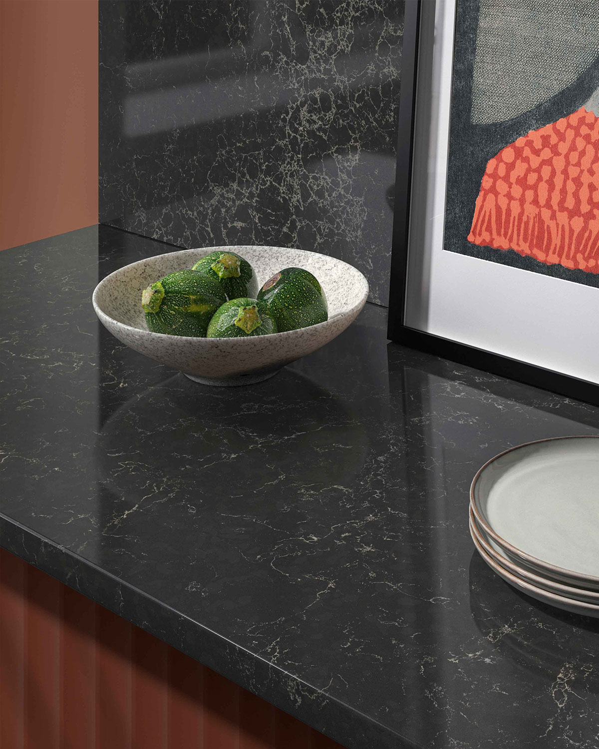 A white bowl filled with limes on a marble countertop.