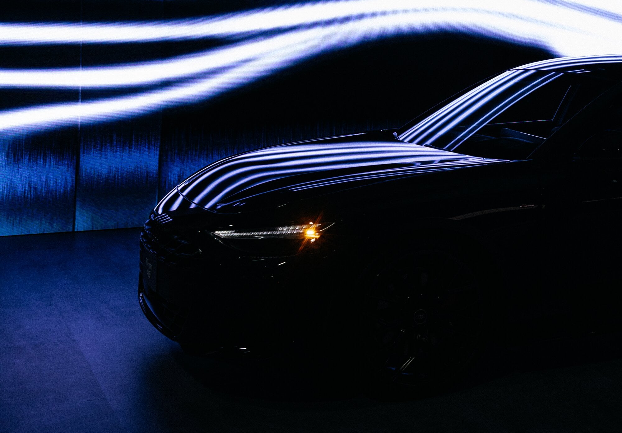 Car in front of backlit wall graphic