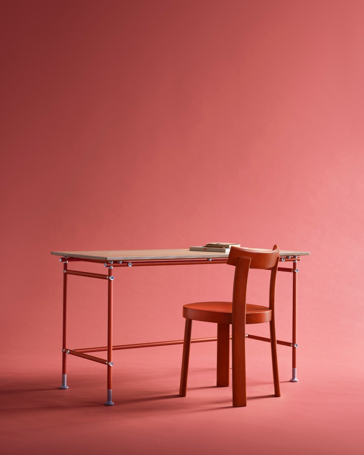 Red chair at wooden desk on red background