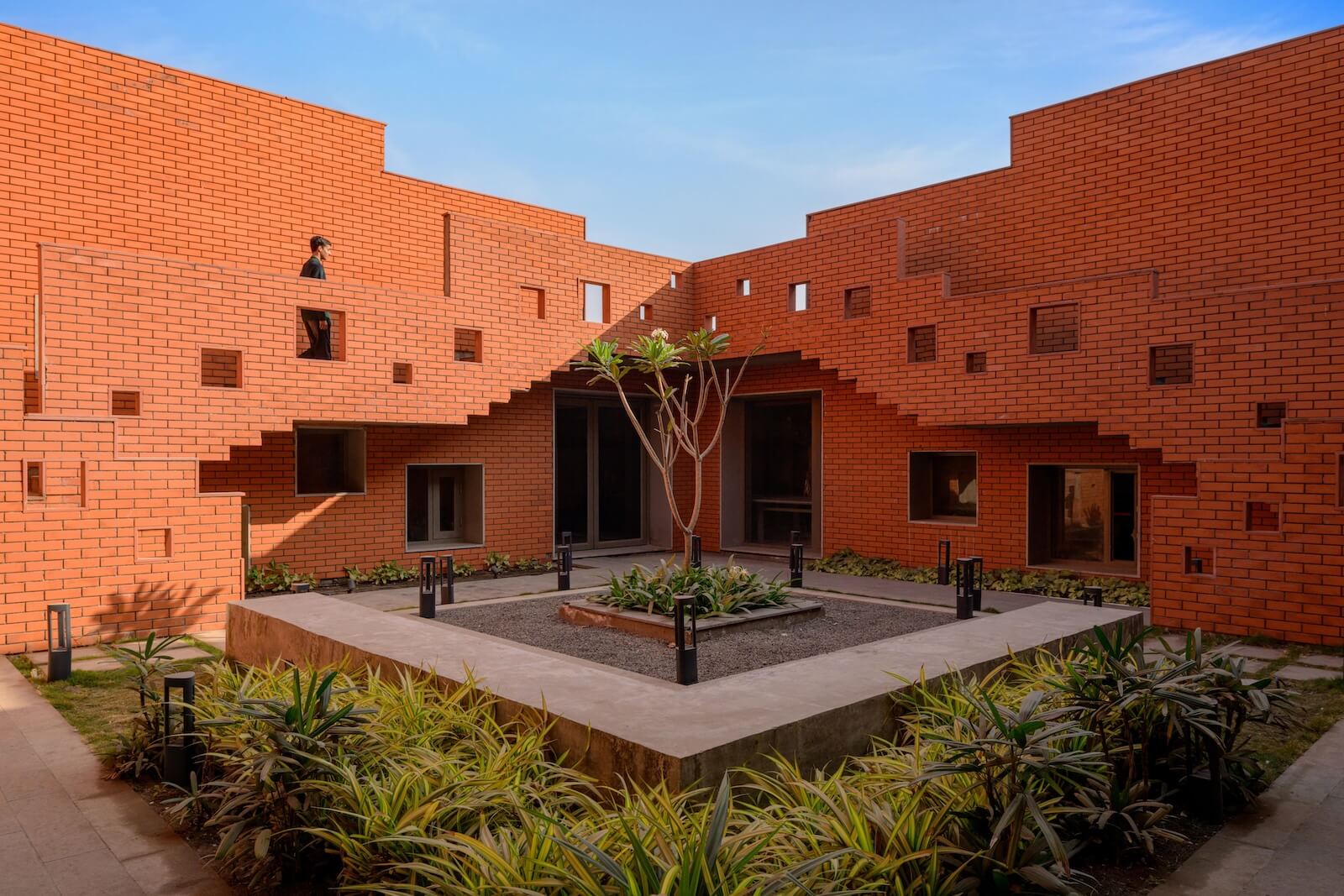A courtyard with a mirrored couple of stair ways in geometric forms at Prestige University by Sanjay Puri Architects