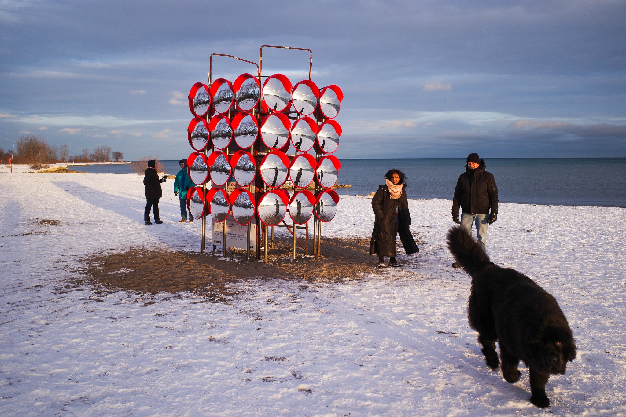 Chimera, an installation at the Winter Stations 2026 festival in Toronto that encloses a lifeguard stand on Woodbine Beach in a series of hub cap-like mirrors.