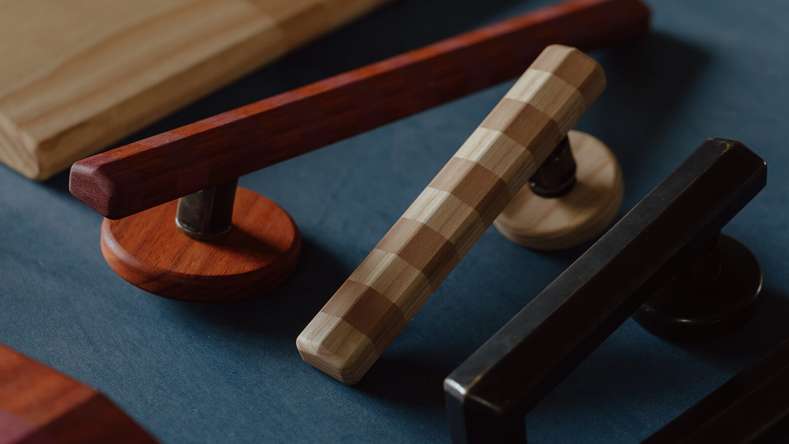 Assorted wooden and metal door hardware with different shapes and finishes displayed on a blue surface.