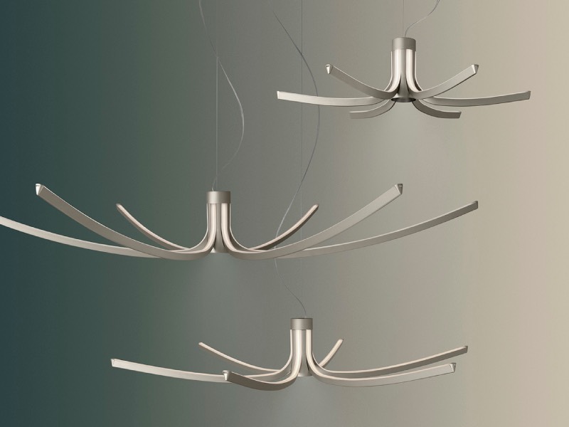 Three modern pendant lights with curved metal arms hang at different heights against a gradient background.
