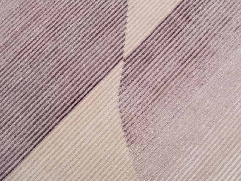 Textured fabric featuring diagonal stripes in alternating shades of beige, cream, and brown.