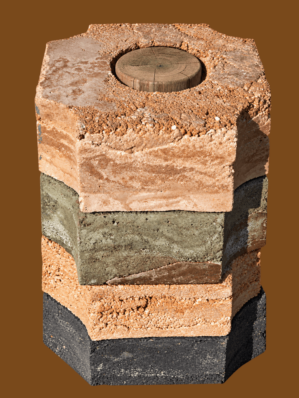 A stack of four hexagonal pavers in varied textures and colors, topped with a circular wooden insert, perfect for October events.