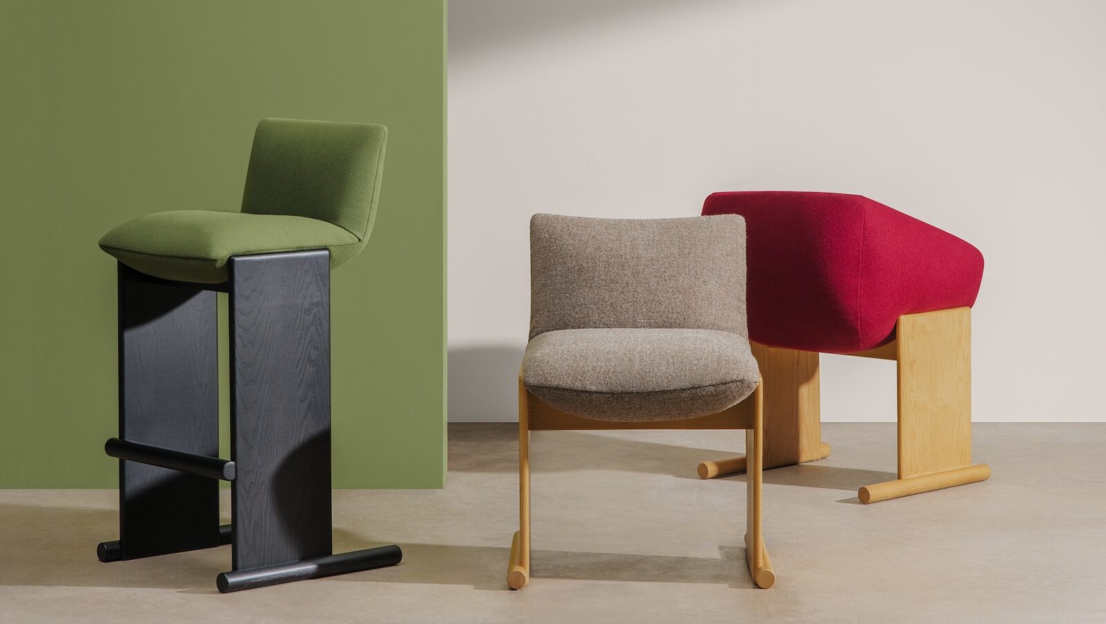 Three Patin chairs — green, beige, and red — designed by Patricia Urquiola stand on a light floor against green and beige background walls, lit by angled sunlight.