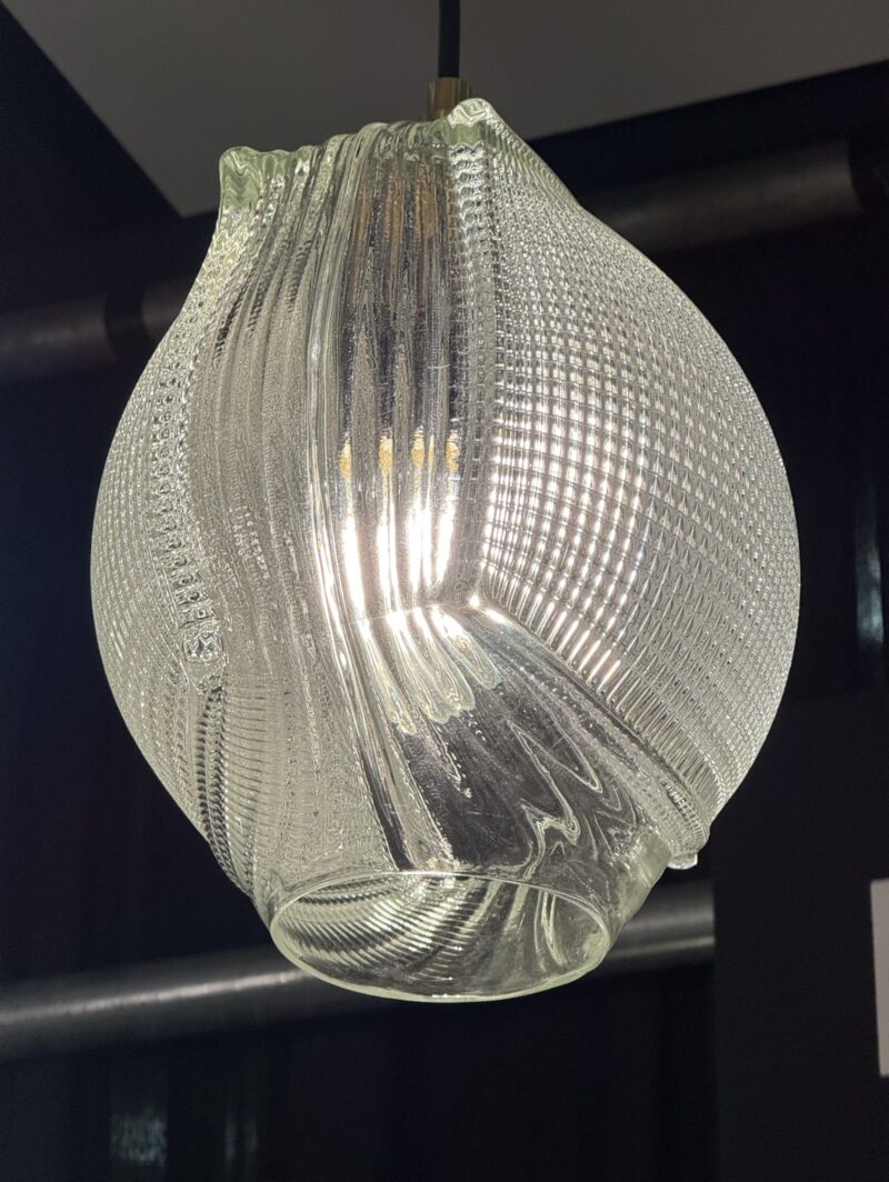 A textured, clear glass pendant light with an onion-shaped silhouette and an internal bulb.